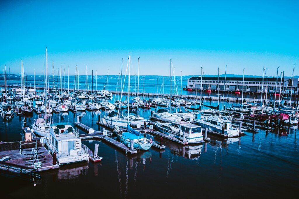 A vibrant marina with numerous yachts and sailboats docked in the calm blue waters, perfect for leisure and travel.